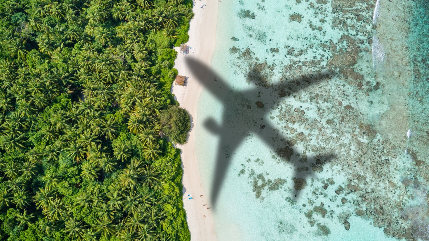 Ombre d'avion survolant une plage paradisiaque